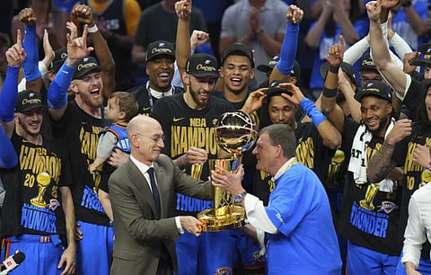 Clay Bennett, center right, chairman the ownership group of the Oklahoma City Thunder, receives the Larry O’Brien Championship Trophy from NBA Commissioner Adam Silver
