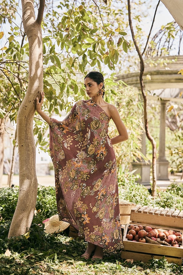 Flowy Saundh Anar Juliet dress featuring delicate hand-painted pomegranate motifs in pastel colours, crafted from lightweight, breathable fabric with a softly structured silhouette for effortless summer elegance.