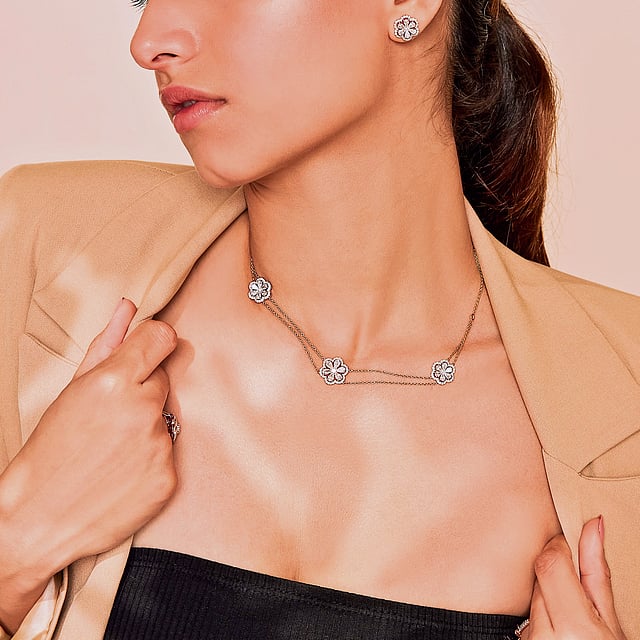 Woman wearing layered lab-grown diamond jewellery from the Blossom collection