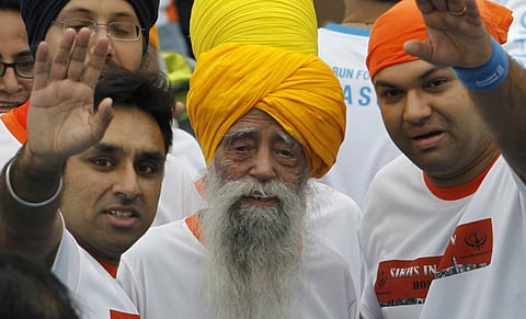 Centenarian marathon runner Fauja Singh, center, smiles after finishing a 10-kilometer race, held as part of the annual Hong Kong Marathon, in Hong Kong in 2013