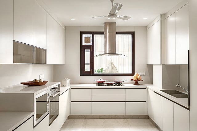 Minimalist salt-inspired kitchen by Nadora featuring white and neutral tones, seamless cabinetry, and soft lighting