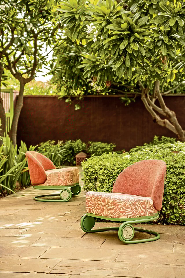 Outdoor furniture in sage green tones contrasted with floral  print upholstery.