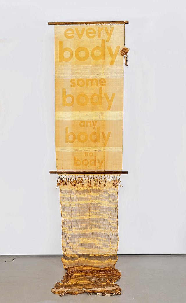 Handwoven kasavu cloth displayed as 
contemporary textile art, showcasing fine gold threadwork