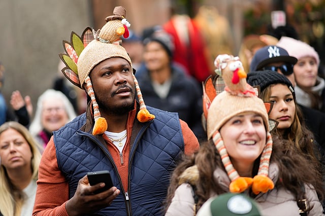 Spectators watch as balloons and floats pass on Sixth Avenue during the Macy's Thanksgiving Day Parade, Thursday, November 27, 2025, in New York