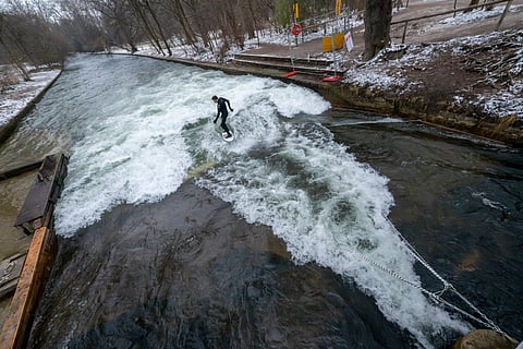 Fire department employees dismantle the installations and devices for an artificial wave on the Eisbach in Munich, Germany