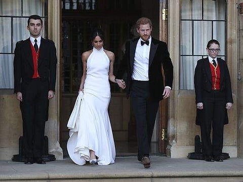 Meghan Markle in her evening dress with Prince Harry leaving for the royal wedding reception.