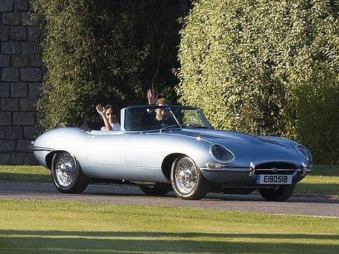 The Duke and Duchess of Sussex in a classic  Jaguar heading off to their wedding reception.