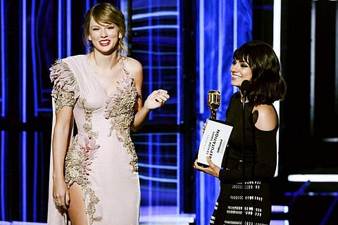Taylor Swift accepts the Top Selling Album award for Reputation from Mila Kunis onstage during the 2018 Billboard Music Award.