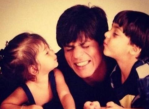 Suhana Khan and Aryan Khan posing for a picture with Shah Rukh Khan