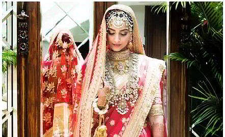 Gorgeous bride Sonam Kapoor looks stunning in a red lehenga with a matching blouse, designed by Anuradha Vakil.