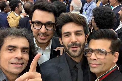 Kartik Aaryan, Imtiaz Ali, Dinesh Vijjan and Karan Johar with PM Narendra Modi in the background.