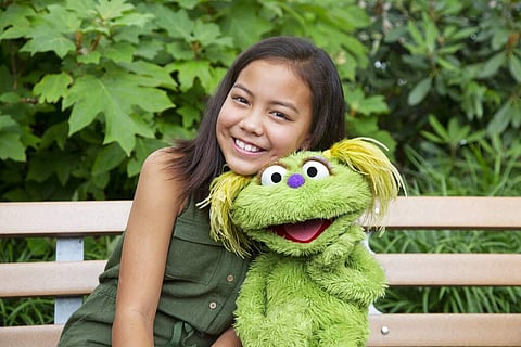 Salia Woodbury with Karli (Flynn Larsen/Sesame Workshop via AP)