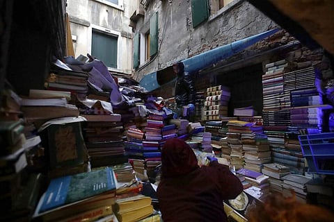 Volunteers pile up damaged books from renowned bookstore 'Acqua Alta' (High Water) after flooding in Venice, Italy  (AP Photo/Luca Bruno)