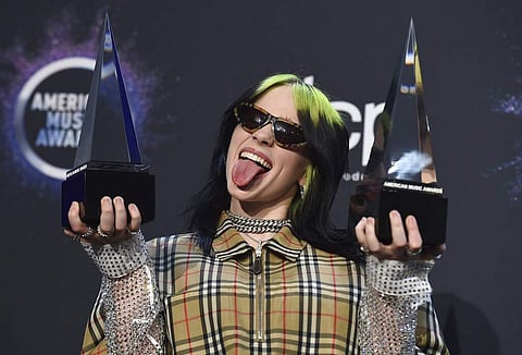 Billie Eilish poses in the press room with the award for new artist of the year and favorite alternative rock artist at the American Music Awards on Sunday.