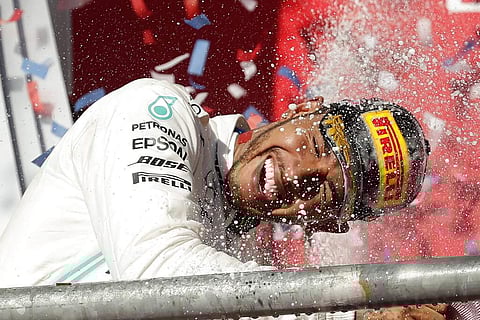Mercedes driver Lewis Hamilton, of Britain, celebrates following the Formula One U.S. Grand Prix auto race at the Circuit of the Americas, in Austin, Texas. (AP Photo/Eric Gay)