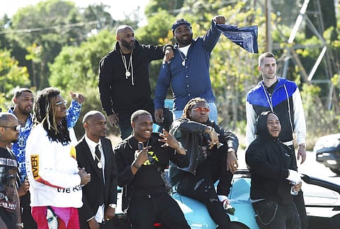 Attendees of a burial service for the late rapper Nipsey Hussle stage to tribute to him before they leave the Forest Lawn Hollywood Hills cemetery, Los Angeles. (Photo by Chris Pizzello/Invision/AP)