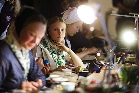 A girl pauses as she decorates Easter eggs at a traditional Easter Market of Germany's Sorb minority in the village Neuwiese, in east Germany. (AP Photo/Markus Schreiber)
