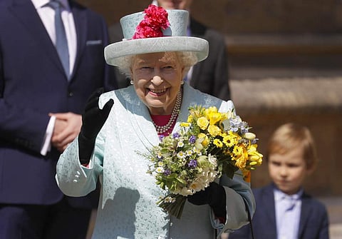 Britain's Queen Elizabeth II waves to the public as she leaves after attending the Easter Mattins Service at St. George's Chapel, at Windsor Castle in England. (AP Photo/Kirsty Wigglesworth)