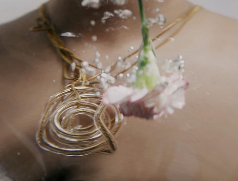 A coiled metal and blown-glass necklace