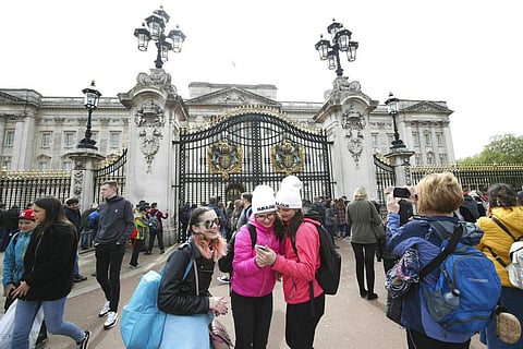 People gather outside Buckingham Palace in London, Monday May 6, 2019, after Prince Harry announced his wife Meghan, Duchess of Sussex had given birth to a baby boy. (Yui Mok/PA via AP)