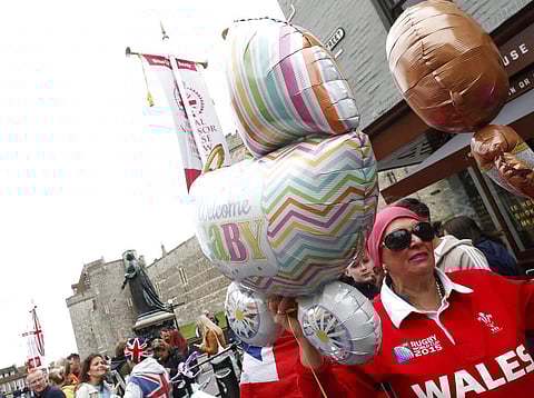 Well-wishers gather outside Windsor Castle in Windsor, South England, after Prince Harry announced that his wife Meghan, Duchess of Sussex, has given birth to a boy. (AP Photo/Alastair Grant)