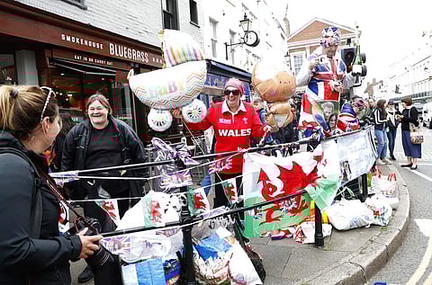 Well-wishers gather outside Windsor Castle in Windsor, South England, after Prince Harry announced that his wife Meghan, Duchess of Sussex, has given birth to a boy. (AP Photo/Alastair Grant)