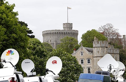 Members of the media gather outside Windsor Castle in Windsor, South England, after Prince Harry announced that his wife Meghan, Duchess of Sussex, has given birth to a boy. (AP Photo/Alastair Grant)