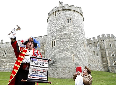A Town Crier announces the birth of a baby boy born to Britain's Prince Harry and Meghan, the Duchess of Sussex, outside Windsor Castle in Windsor, South England. (AP Photo/Alastair Grant)