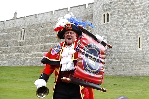A Town Crier announces the birth of a baby boy born to Britain's Prince Harry and Meghan, the Duchess of Sussex, outside Windsor Castle in Windsor, South England. (AP Photo/Alastair Grant)