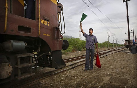 A railway guard clears the track for a train carrying drinking water, at Jolarpet railway station. The 50-tank train carries 2.5 million litres of water on its daily sojourns. (AP Photo/Manish Swarup)