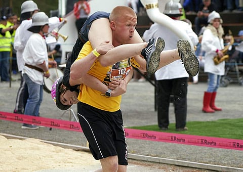 People take part in the wife carrying race, a 278-yard obstacle course, during the 24th world championships in Sonkajarvi, Finland (AP Photo/David Keyton)