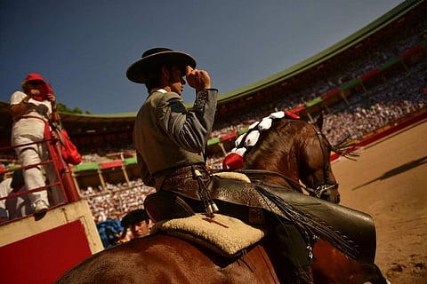 Roberto Armendariz, 33, Spanish 'rejoneador' or mounted bullfighter, enters the bullring for a horseback bullfight at San Fermin Fiestas, northern Spain. (AP Photo/Alvaro Barrientos)