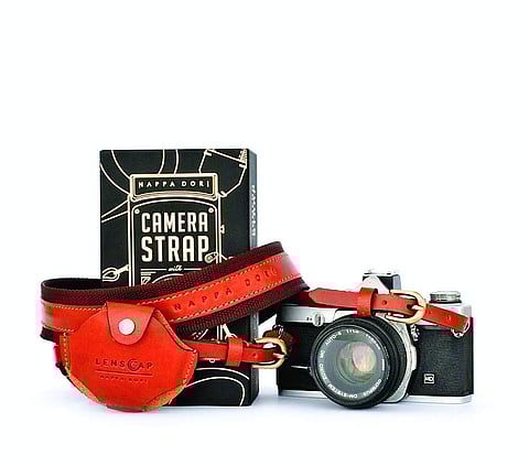 Check out this handcrafted leather strap from Nappa Dori. It’s got gold-finished buckles that accent the brown leather and a tiny lens-cap holder on the strap for your, well, lens cap. `4,800.