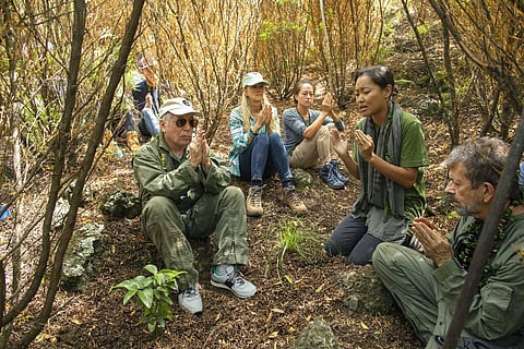Paul Simon joins a prayer led by Aimee Sato, prior to planting a lama tree at Auwahi Forest Reserve on Maui, Hawaii, as part of a forest restoration effort. (Anna Kim/Honolulu Star-Advertiser via AP)