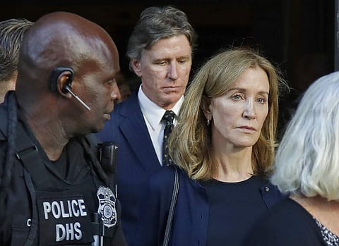 Felicity Huffman leaves federal court with her husband William H Macy and her brother Moore Huffman Jr. after she was sentenced in Boston. (AP Photo/Michael Dwyer)