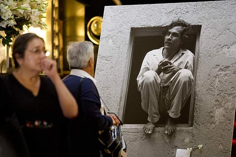 People walk up to a photo of Francisco Toledo at a memorial at Bellas Artes Palace in Mexico City to celebrate the late Mexican painter who was well-known for his activism. (AP Photo/Eduardo Verdugo)