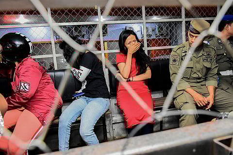 Women detained during a raid in Makassar (AFP/Indra Abriyanto)