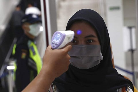 A medical team member checks a passenger's body temperature at a Mass Rapid Transit (MRT) station in Jakarta, Indonesia. (AP Photo/Tatan Syuflana)