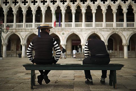Gondoliers chat as they wait for customers near St Mark's square in Venice. (AP Photo/Francisco Seco)