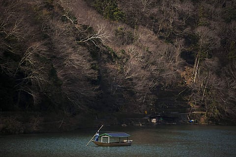 A boatman glides his boat across the river in the Arashiyama district of Kyoto, Japan. Widening travel restrictions and closures have gutted the tourism industry in Japan. (AP Photo/Jae C Hong)