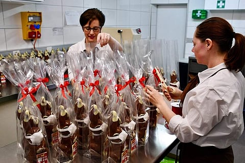 Employees prepare chocolate bunnies with face masks in a confectionery in Veltheim, Switzerland. (Detlev Munz/Keystone via AP)