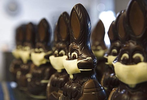 Chocolate rabbits with face masks are lined up at Cocoatree shop in Lonzee, Belgium. Many chocolatiers have resorted to online sales, home delivery or pick up on site. (AP Photo/Virginia Mayo)