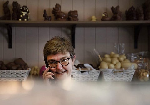 Marleen Van Volsem, owner of Praleen, takes orders over the phone in Halle, Belgium. During lockdown, many shops have resorted to online sales, delivery or pick up on site. (AP Photo/Virginia Mayo)