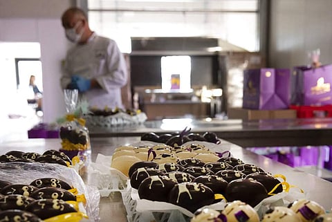One of Belgium's top chocolate producers Dominique Persoone stands in front of trays of chocolates at his Chocolate Line warehouse in Bruges, Belgium. (AP Photo/Virginia Mayo)