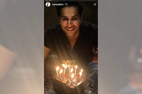 Varun Dhawan cuts a heart-shaped cake at home (Photo: IANS)