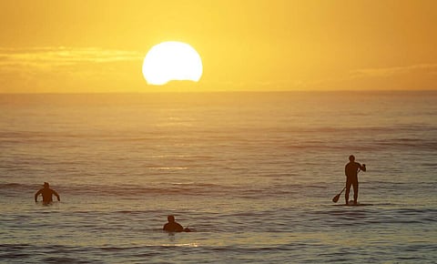 Surfers enjoy a sunrise surf at Sumner Beach as level four COVID-19 restrictions are eased in Christchurch, New Zealand. (AP Photo/Mark Baker)