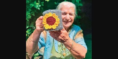 Sheela Bajaj holding a crochet mug sleeve created by her