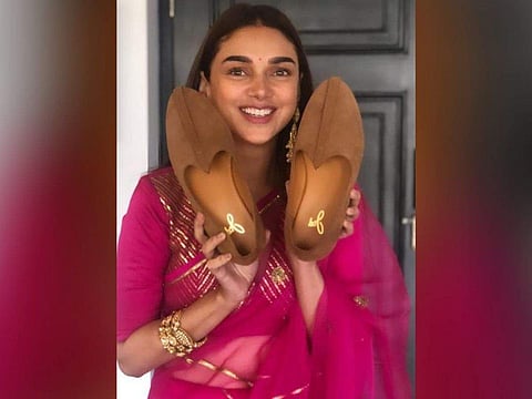 Aditi Rao Hydari holding Vaibhav Rekhi's shoes for the joota chhupai ritual. Courtesy: Instagram