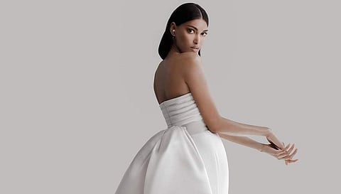 Hand-draped twist detail silk cady bodice and stretch crepe column with detachable silk satin sculptural bustle bow.