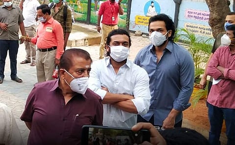 Actor Suriya, his brother Karthi and father Sivakumar wait in line to cast their votes